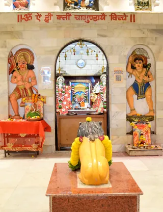Inside the mandir, with the Chamunda mantra painted above the sanctum